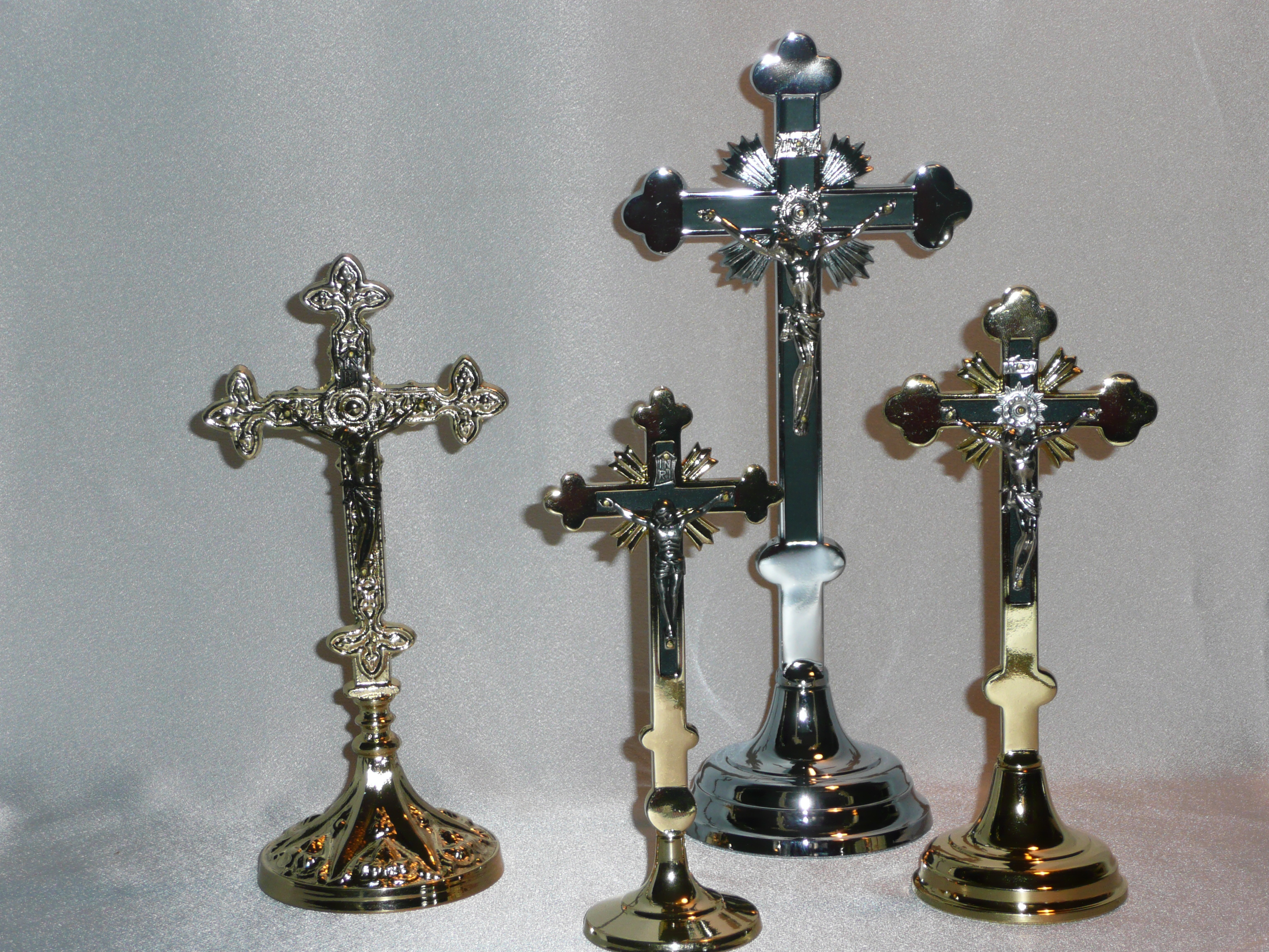 Kříže kovové-mosazné nebo bronzové na postavení.